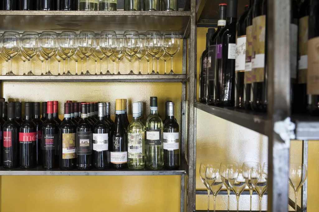 Pictured are some metal shelves with wine glasses and bottles.